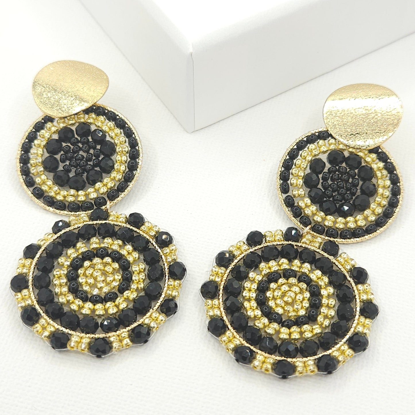 Statement artisanal earrings featuring two dangling suns with a blend of black Czech beads and golden Rondelle beads