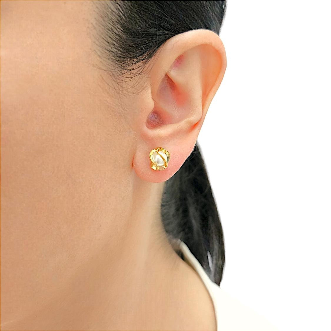 Floral-inspired stud earrings, with a pearl delicately cradled within intricate, goldtone lines