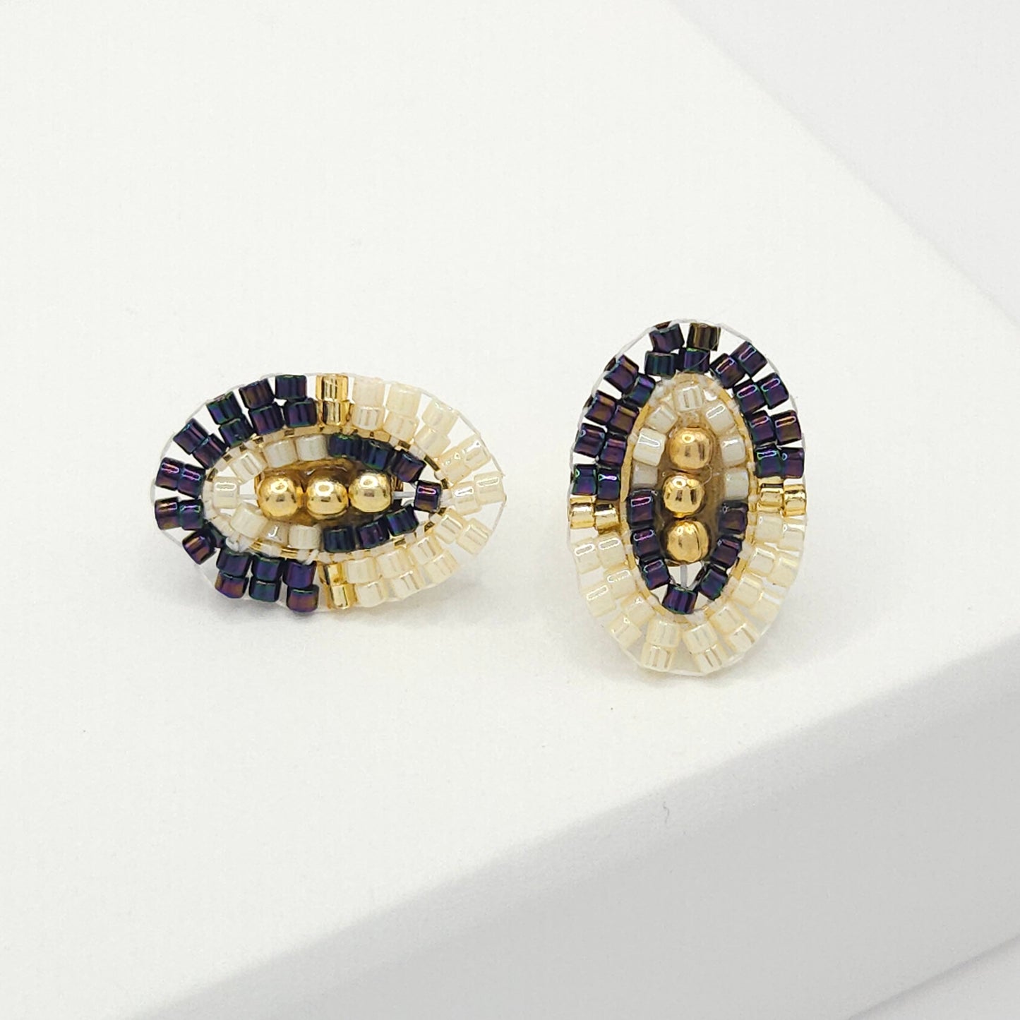 Oval-shaped stud earrings with purple and white Miyuki beads