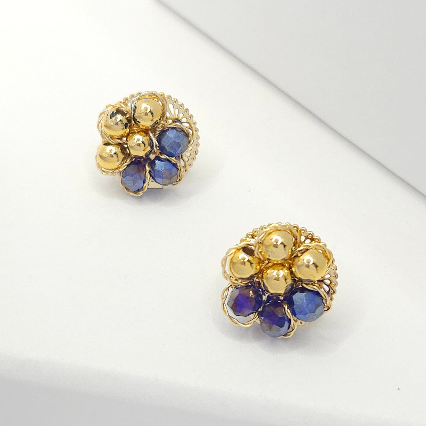 Flower-shaped stud earrings with goldtone spheres and blue Murano glass