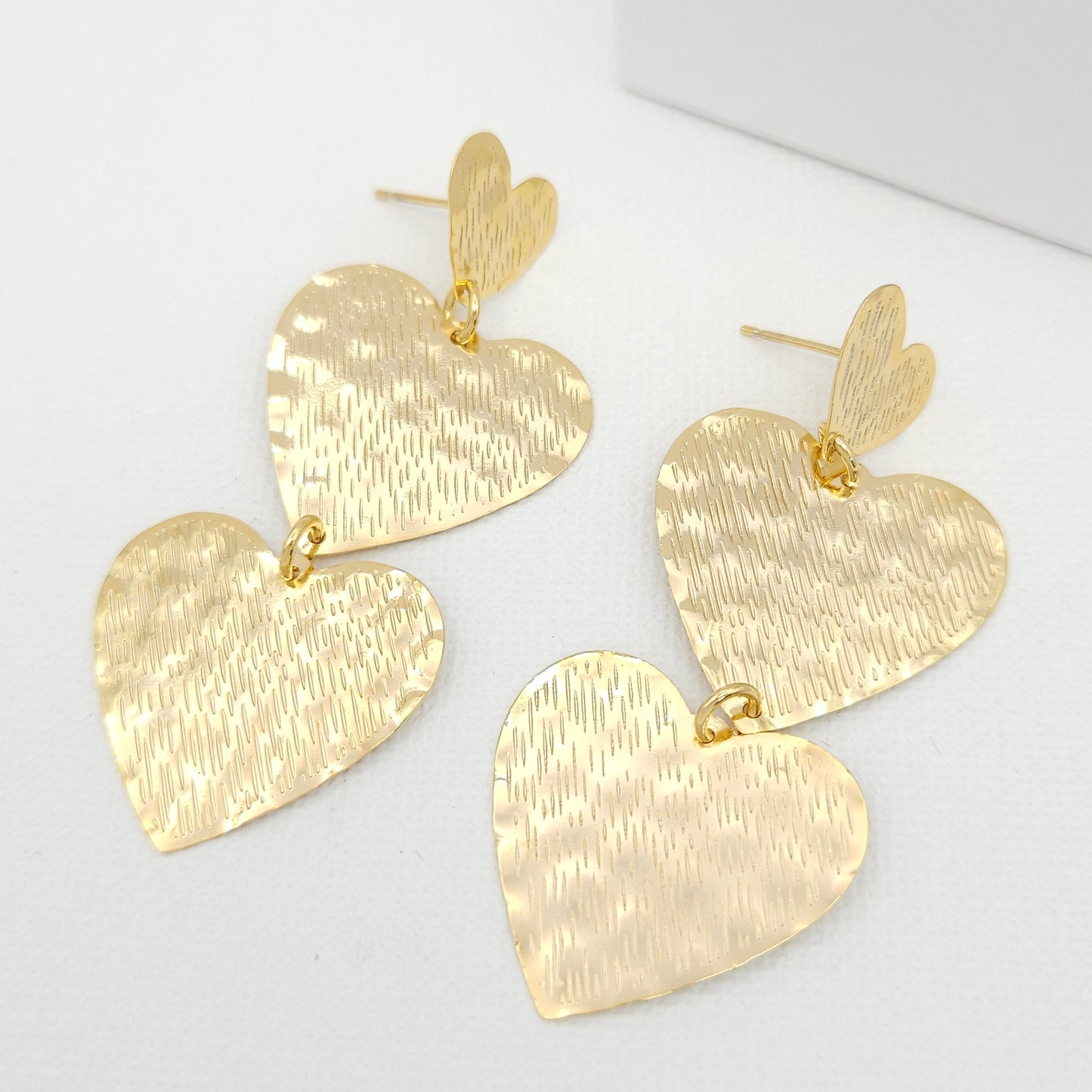 Handmade 18k gold plated bronze statement earrings showcasing a trio of hearts