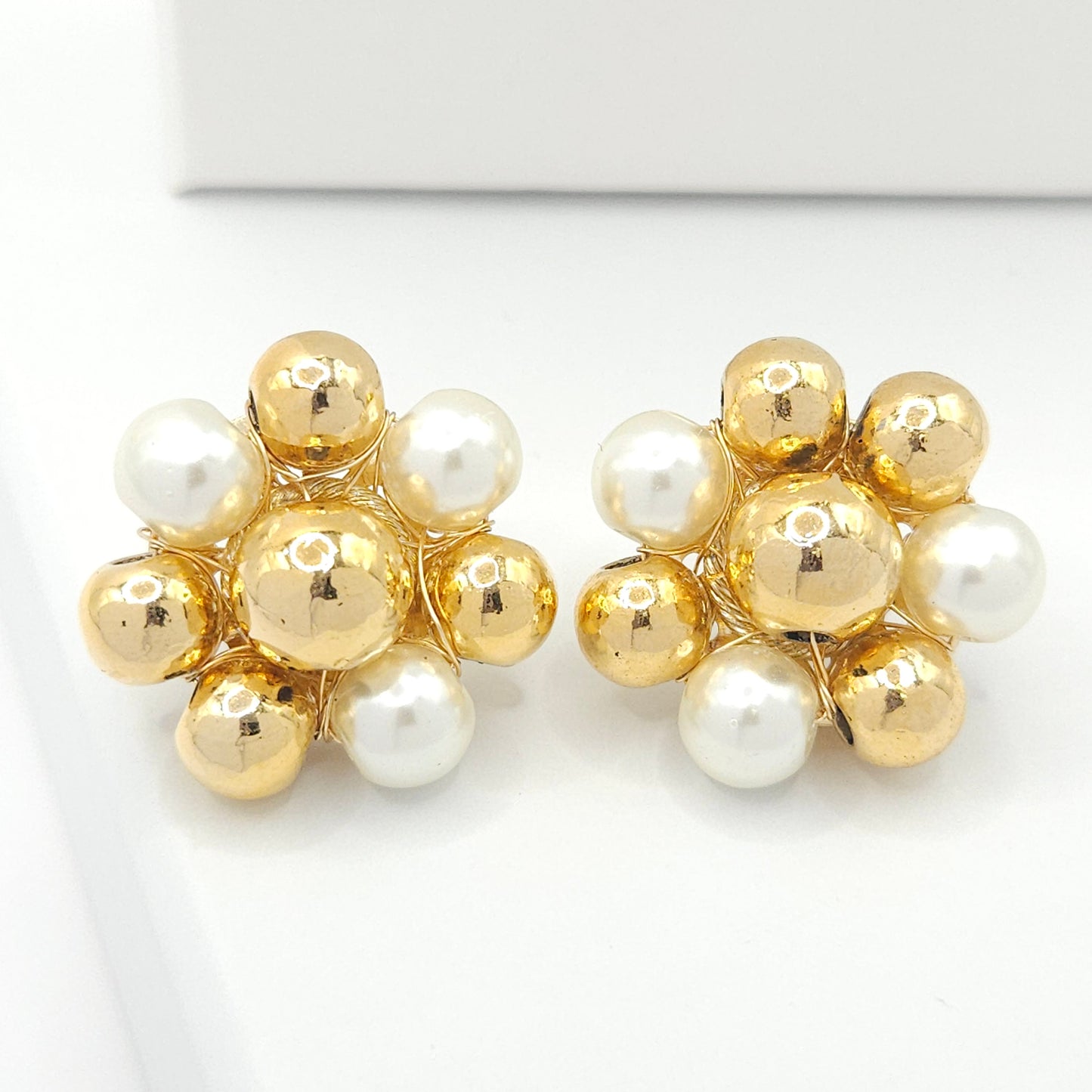 Large stud earrings with a flower shape, crafted from goldtone spheres and delicate pearls
