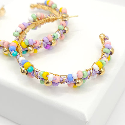 Close-up of golden hoop soft pastel Czech beads, focused on lower right detail, blurring toward the upper left corner