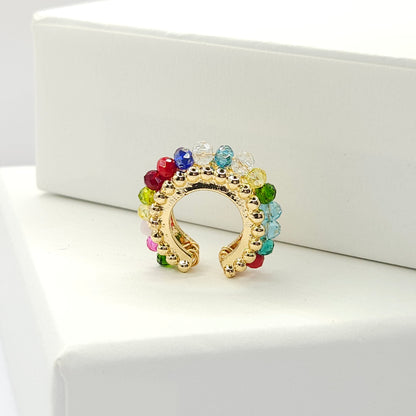 Golden ear cuff featuring an array of multicolour faceted rondelle glass beads standing on a white base