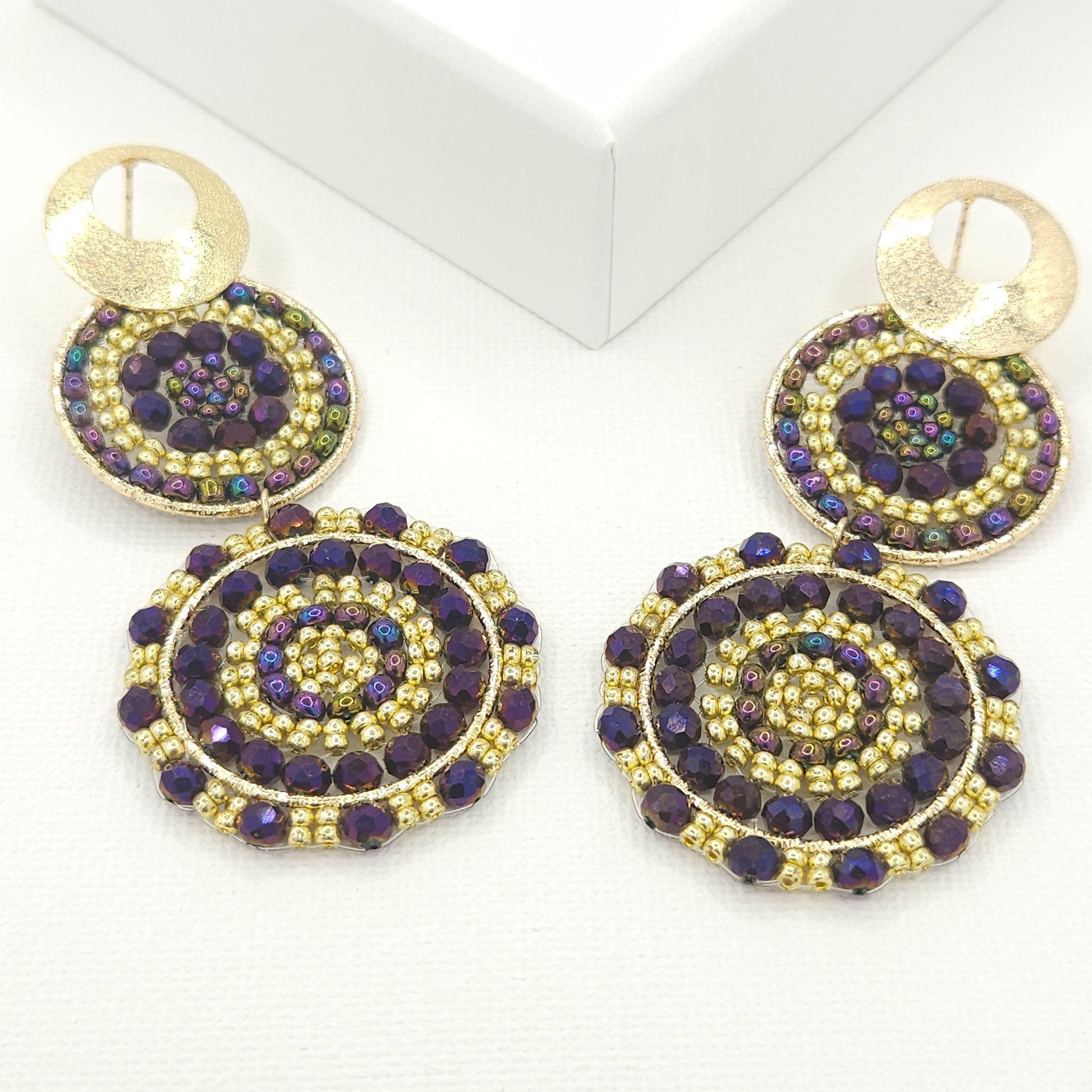 Statement artisanal earrings featuring two dangling suns with a blend of purple palatinate Czech beads and golden Rondelle beads